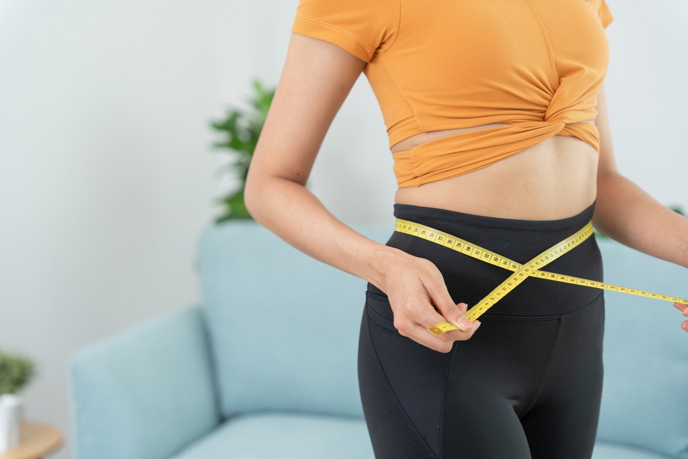 Diet and dieting. Beauty slim female body use tape measure. Woman in exercise clothes achieves weight loss goal for healthy life, crazy about thinness, thin waist, nutritionist.